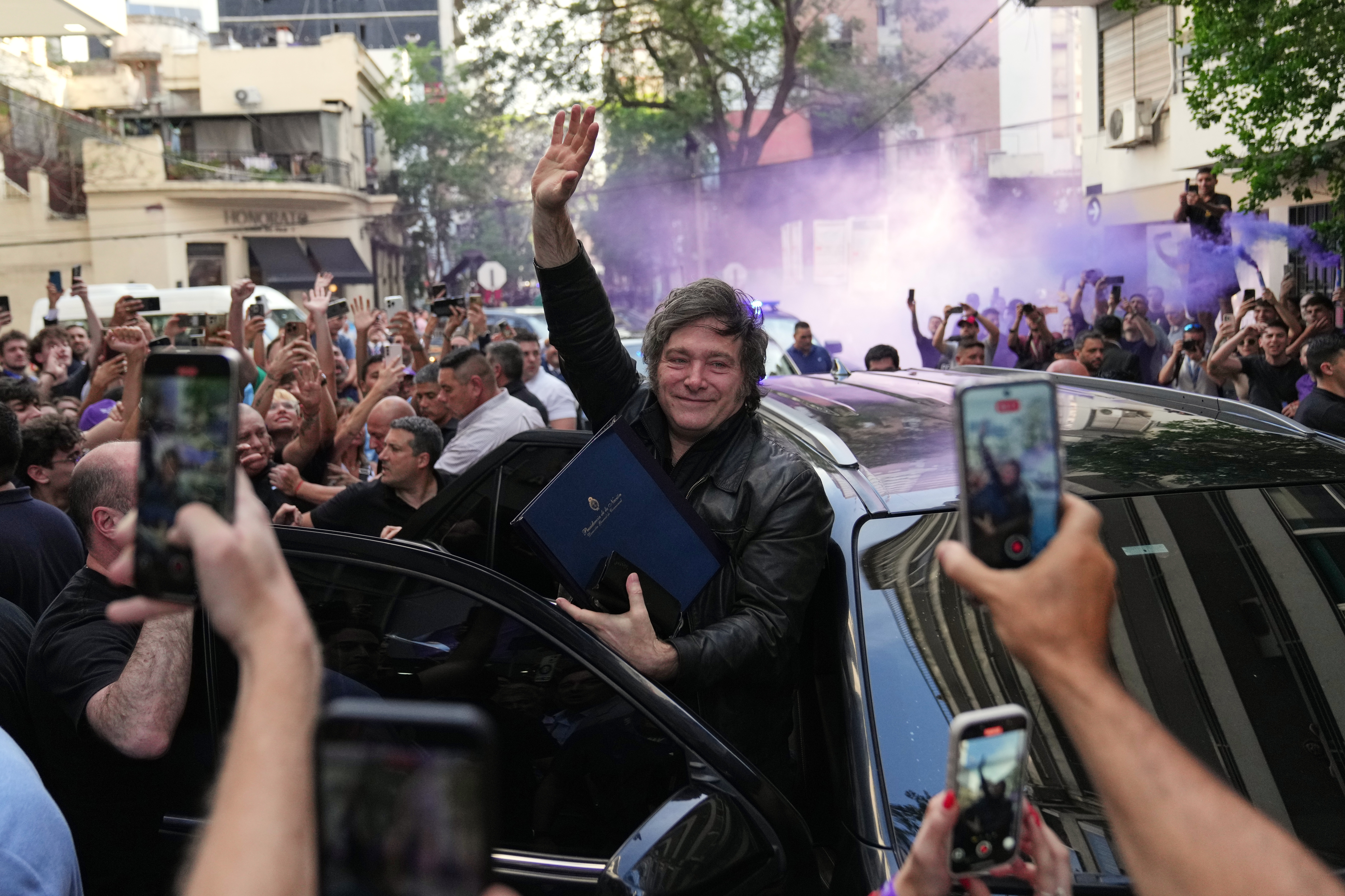 Argentine President Javier Milei waves to supporters upon arriving at a hotel in Rosario, Argentina, Thursday.